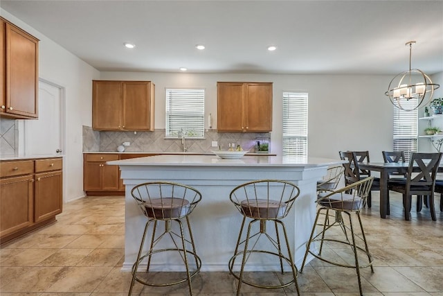 kitchen featuring a kitchen breakfast bar, a center island, hanging light fixtures, and backsplash