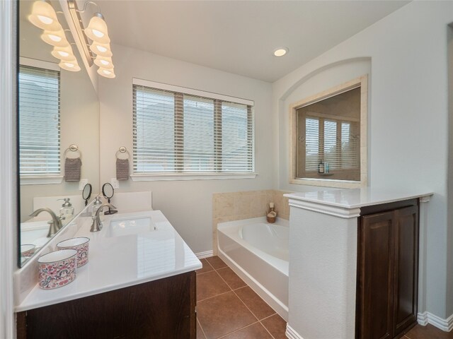 bathroom featuring tile patterned floors, vanity, an inviting chandelier, and a bath