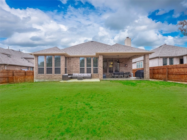 rear view of house with an outdoor living space, a lawn, ceiling fan, and a patio area