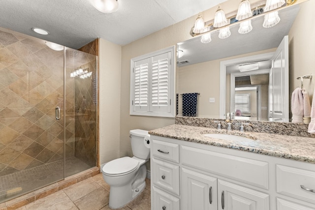 bathroom with a shower with shower door, vanity, toilet, tile patterned floors, and a textured ceiling