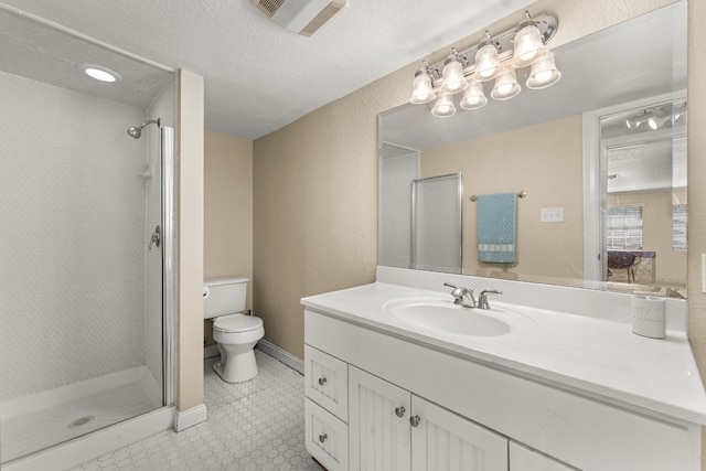 bathroom with vanity, a shower with shower door, a textured ceiling, and toilet