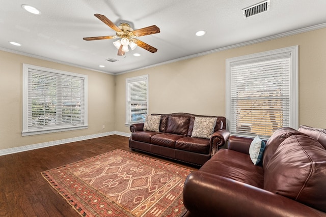 living room featuring dark wood-type flooring, ornamental molding, and ceiling fan