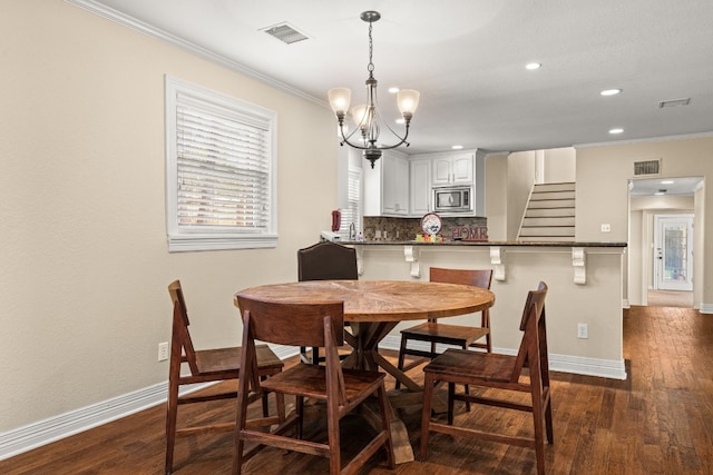 dining space featuring sink, crown molding, a notable chandelier, and dark hardwood / wood-style floors