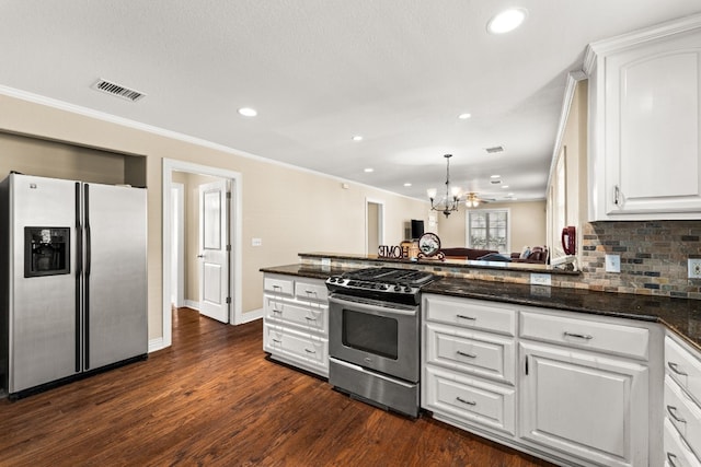 kitchen featuring stainless steel appliances, white cabinetry, decorative light fixtures, and dark stone counters