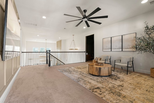 sitting room with carpet flooring and ceiling fan with notable chandelier