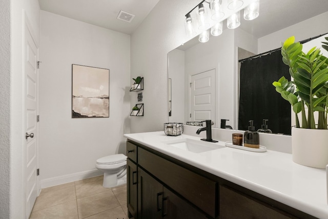 bathroom with tile patterned flooring, vanity, and toilet