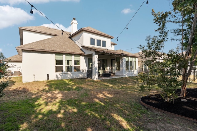 rear view of property featuring a yard and a patio area