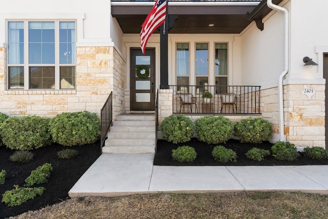 doorway to property featuring stone siding and stucco siding