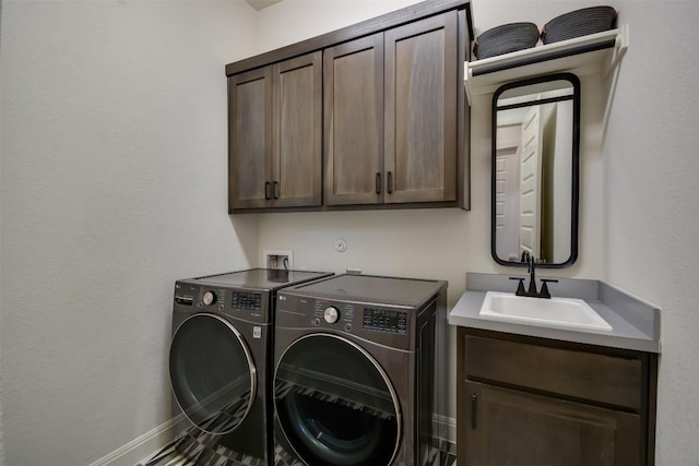 laundry room with cabinet space, a sink, baseboards, and separate washer and dryer