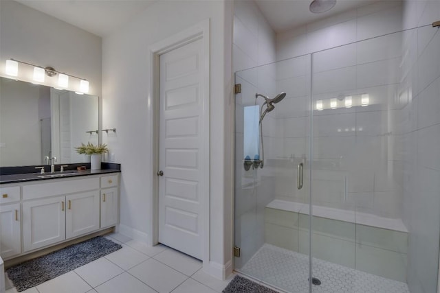 bathroom featuring a stall shower, vanity, baseboards, and tile patterned floors