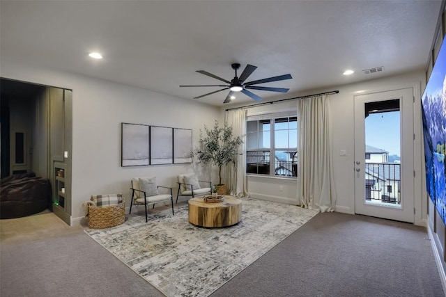 living area featuring light carpet, visible vents, and recessed lighting