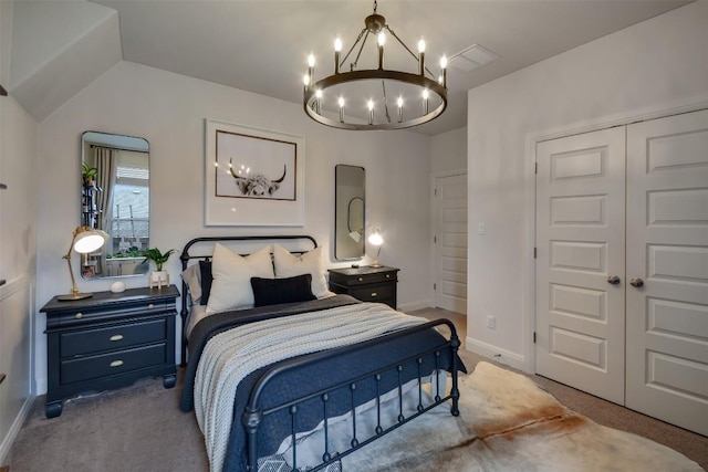 bedroom with a closet, an inviting chandelier, light carpet, vaulted ceiling, and baseboards