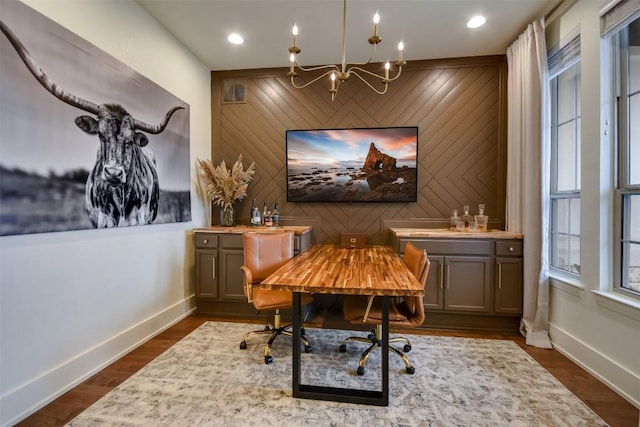 office area featuring an accent wall, visible vents, baseboards, and dark wood-style floors