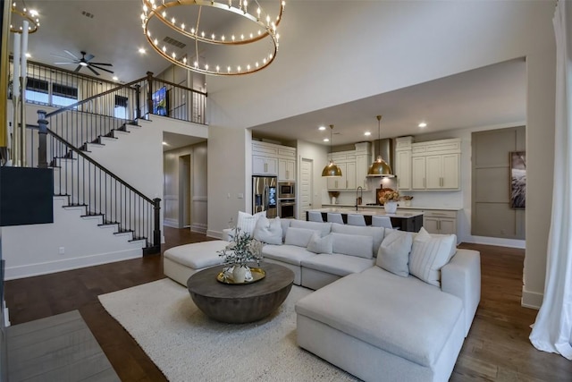 living room with baseboards, stairway, dark wood-type flooring, and recessed lighting