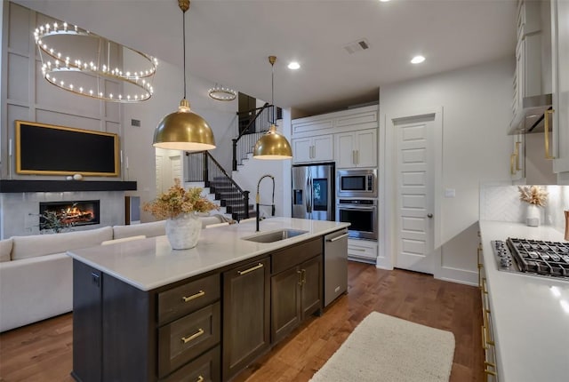 kitchen featuring stainless steel appliances, white cabinets, light countertops, and a sink