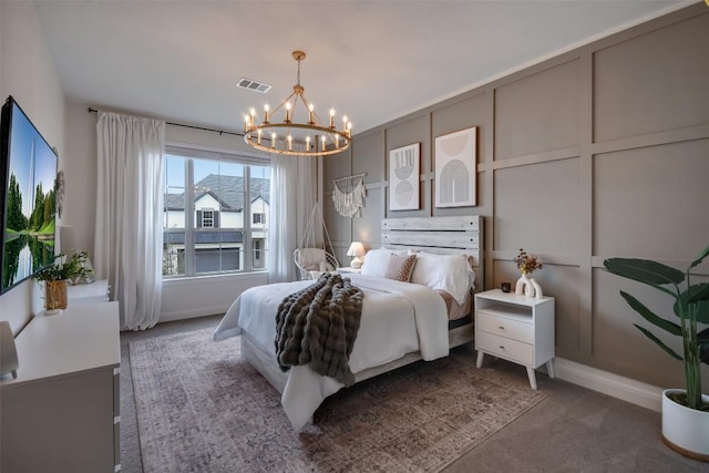 bedroom with a chandelier, visible vents, a decorative wall, and carpet flooring