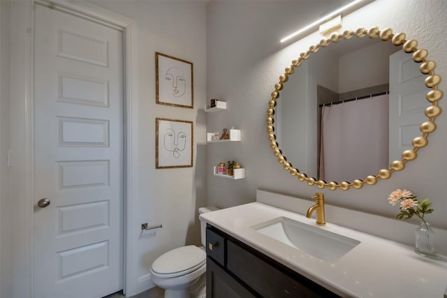 bathroom featuring toilet, curtained shower, and vanity