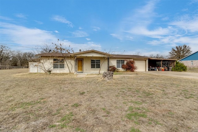 single story home with a garage, a front yard, and a carport