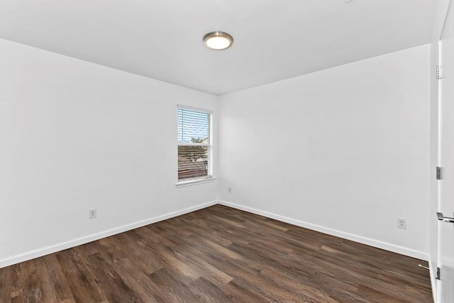 unfurnished room with dark wood-type flooring