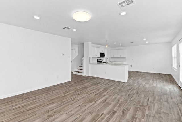 unfurnished living room with sink and light wood-type flooring