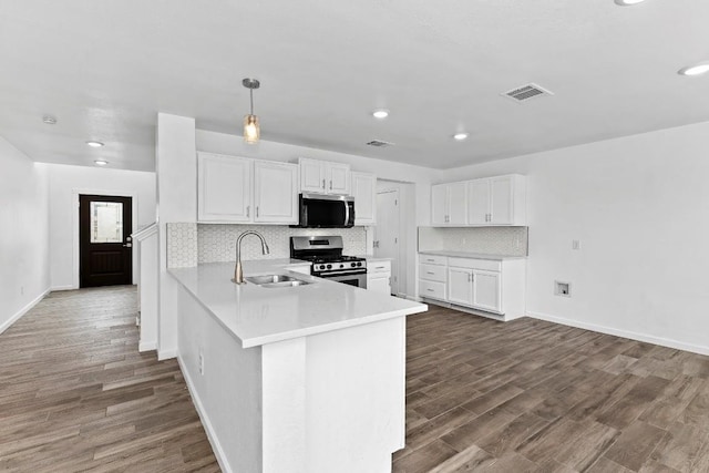 kitchen with sink, appliances with stainless steel finishes, hanging light fixtures, white cabinets, and kitchen peninsula