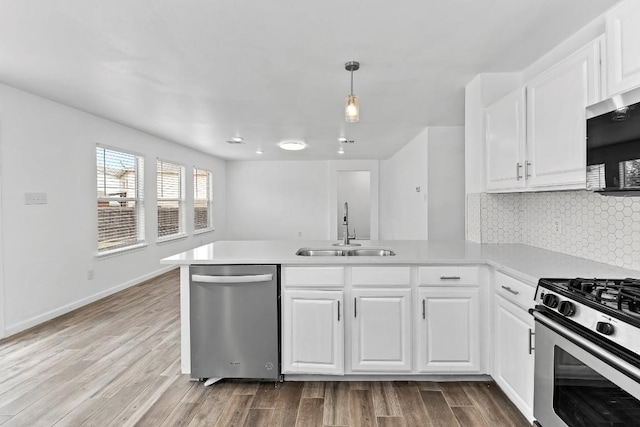 kitchen featuring sink, stainless steel appliances, kitchen peninsula, and white cabinets