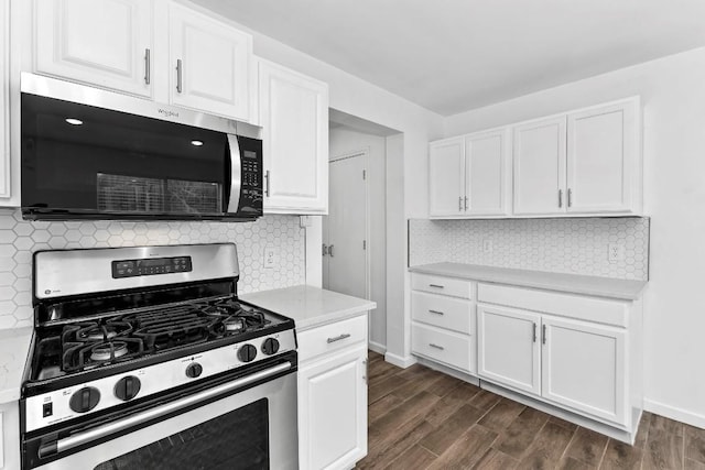 kitchen featuring white cabinetry, appliances with stainless steel finishes, dark wood-type flooring, and backsplash