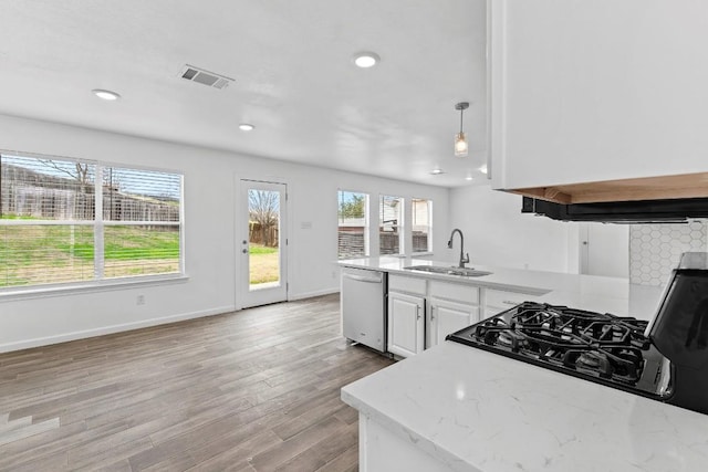 kitchen with sink, white cabinetry, decorative light fixtures, light wood-type flooring, and dishwasher