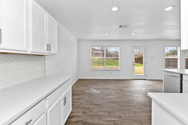 kitchen featuring tasteful backsplash, light stone counters, dark hardwood / wood-style floors, dishwasher, and white cabinets