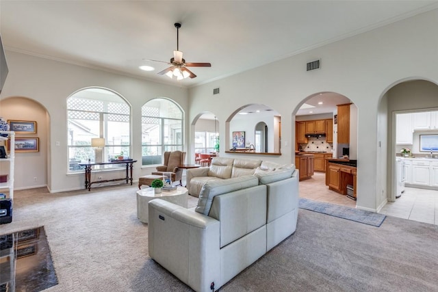 carpeted living room featuring crown molding and ceiling fan