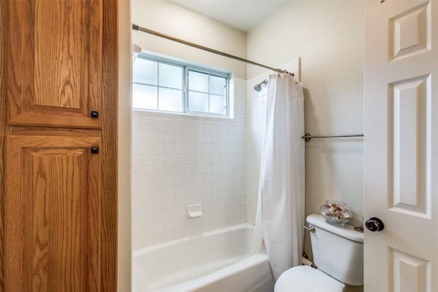 bathroom featuring shower / bath combination with curtain and toilet