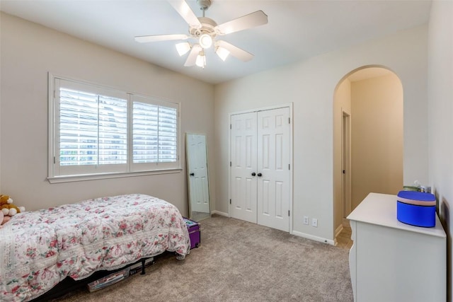 bedroom with light colored carpet, a closet, and ceiling fan