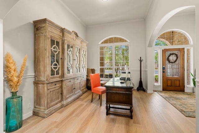 office space featuring light wood-style floors, baseboards, and crown molding