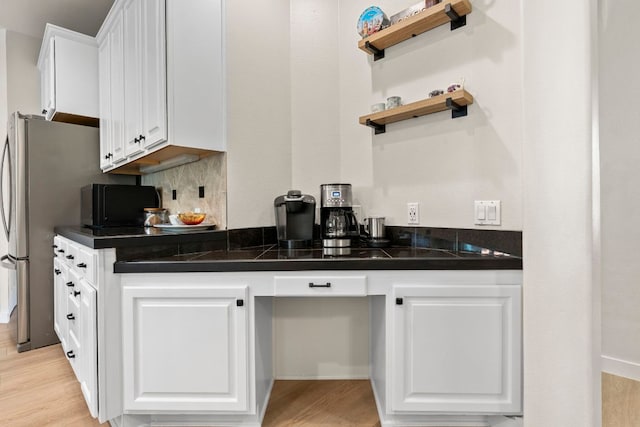 bar featuring decorative backsplash and light wood-style floors