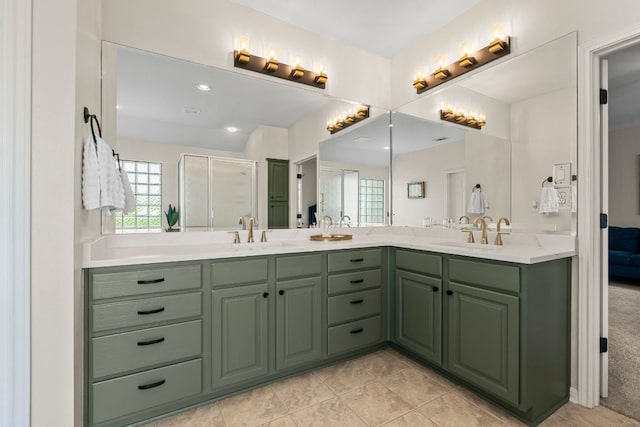 bathroom featuring double vanity, a sink, a shower with door, and tile patterned flooring