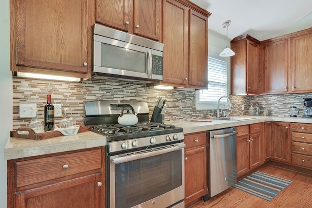 501 S College St Unit 501, Georgetown, TX 78626 - kitchen with tasteful backsplash, stainless steel appliances, decorative light fixtures, and light hardwood / wood-style flooring