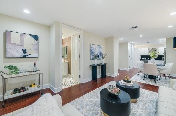 living room featuring recessed lighting, dark wood-style flooring, visible vents, and baseboards