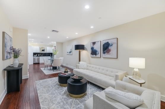 living area with baseboards, dark wood finished floors, visible vents, and recessed lighting