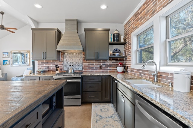 kitchen with stainless steel appliances, custom range hood, sink, and light stone counters