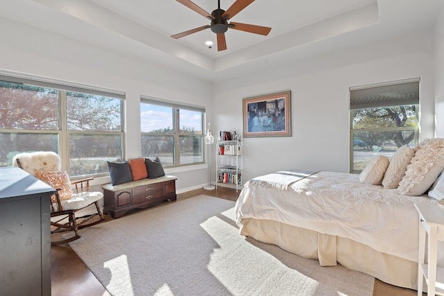 bedroom featuring a raised ceiling and ceiling fan