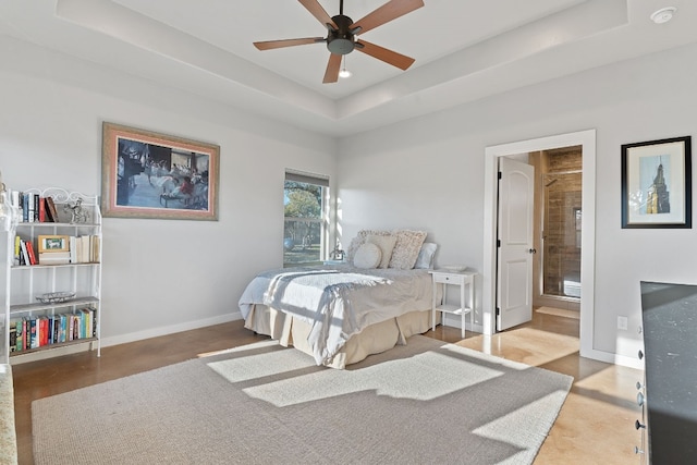 bedroom featuring connected bathroom and a tray ceiling