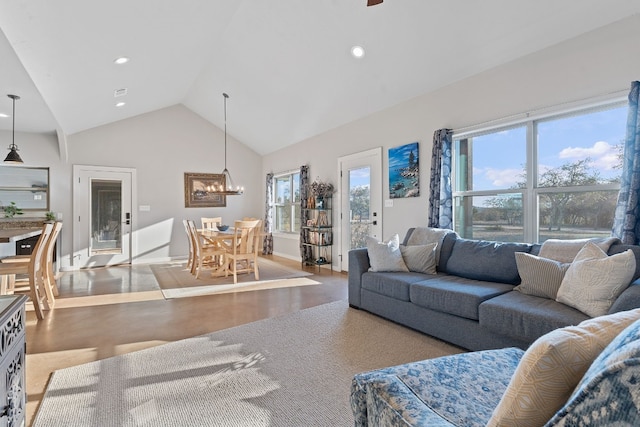 living room featuring an inviting chandelier, hardwood / wood-style floors, high vaulted ceiling, and a healthy amount of sunlight