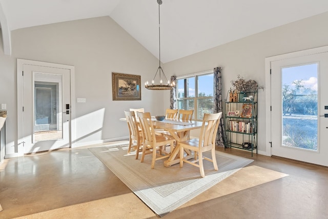 dining room with a healthy amount of sunlight, concrete flooring, and a notable chandelier