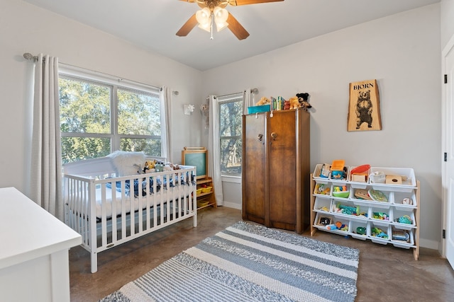 bedroom featuring a nursery area and ceiling fan