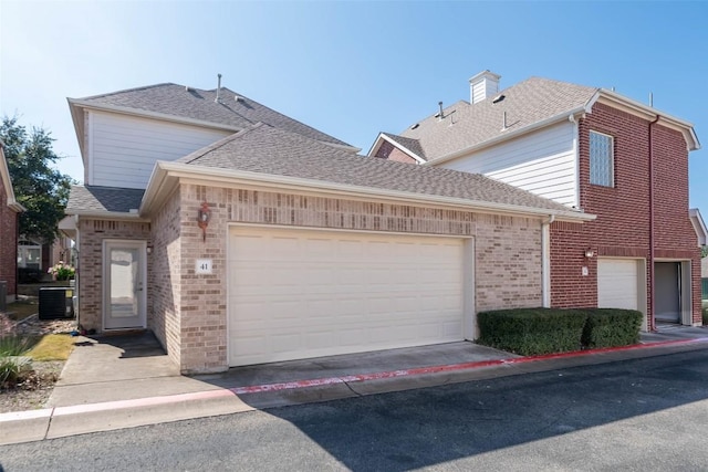 front of property with a garage and central air condition unit