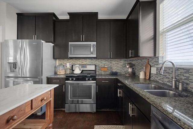 kitchen featuring sink, stainless steel appliances, dark hardwood / wood-style flooring, light stone countertops, and decorative backsplash