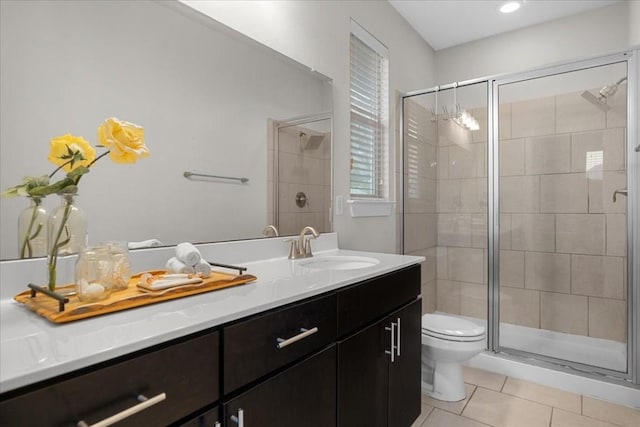 bathroom featuring vanity, a shower with door, tile patterned floors, and toilet