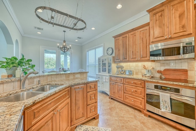 kitchen with sink, hanging light fixtures, stainless steel appliances, light stone countertops, and backsplash