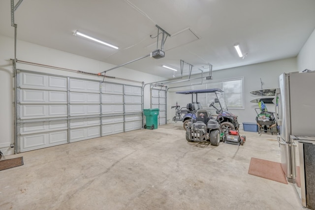 garage with stainless steel refrigerator and a garage door opener