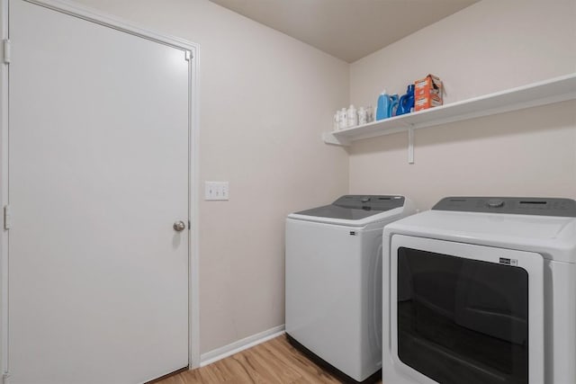 washroom with light hardwood / wood-style floors and washer and dryer